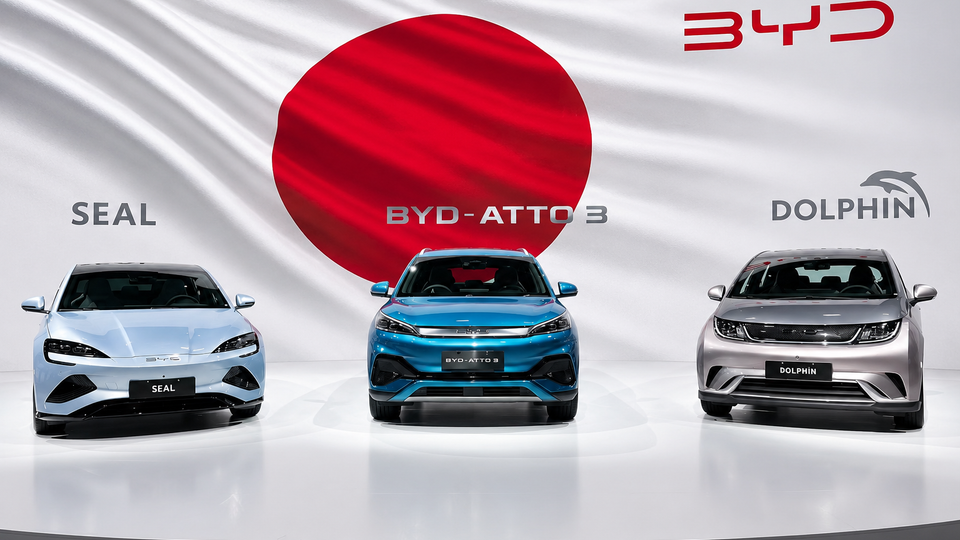 Three BYD cars on a white platform with a large red circle backdrop and BYD logos: SEAL, BYD-ATTO 3, and DOLPHIN labeled cars from left to right.