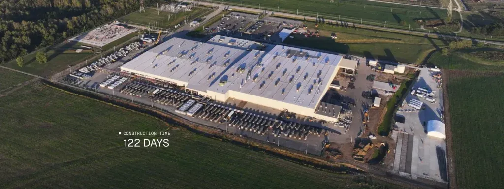 Aerial view of a large warehouse complex under construction with rows of trucks and equipment, surrounded by fields and roads; overlay text reads 'Construction Time 122 Days'.