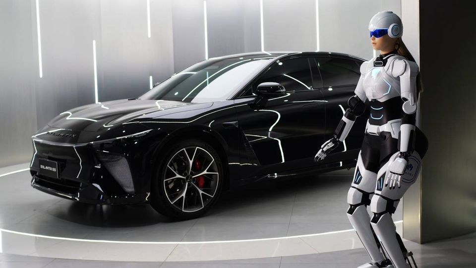 Robot umanoide accanto ad auto sportiva Chery in showroom