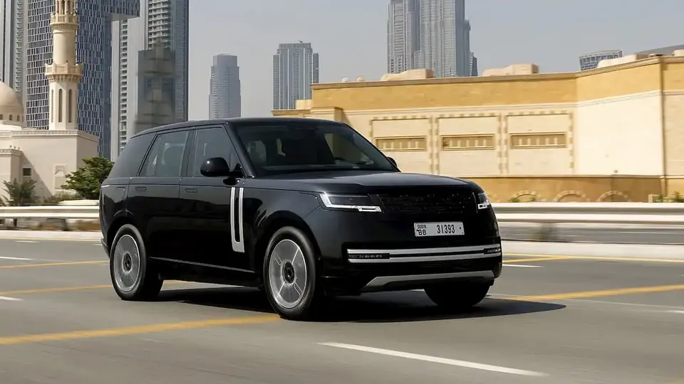 Black luxury SUV driving on a highway with a modern city skyline in the background, including tall skyscrapers and a beige building.